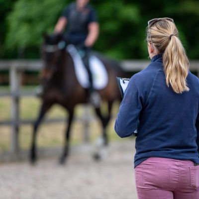 Vet watching horse being ridden